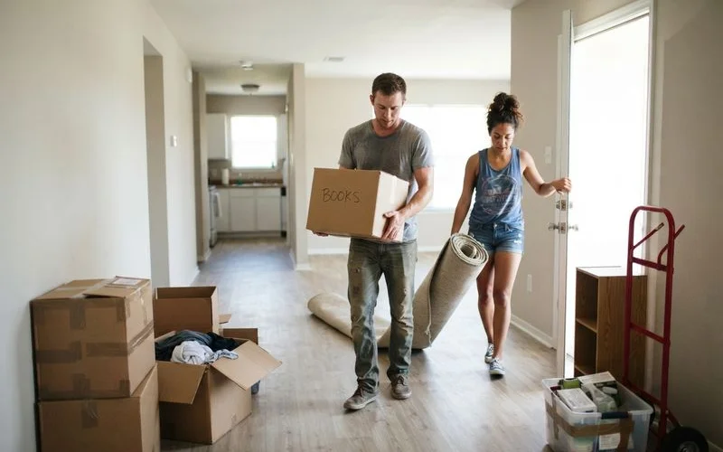 A stack of moving boxes and a lease folder on the floor of an empty Houston apartment ready for move-in
